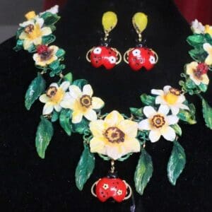 A necklace and earrings set with flowers on them.