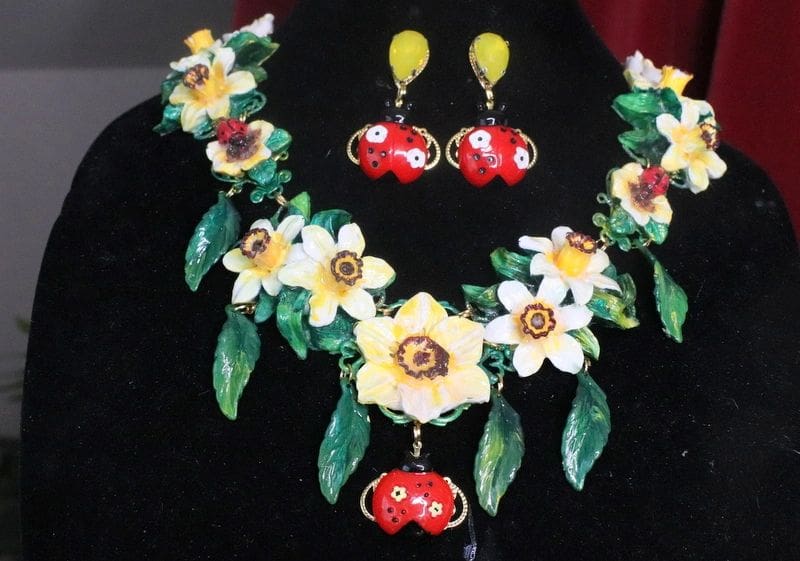 A necklace and earrings set with flowers on them.