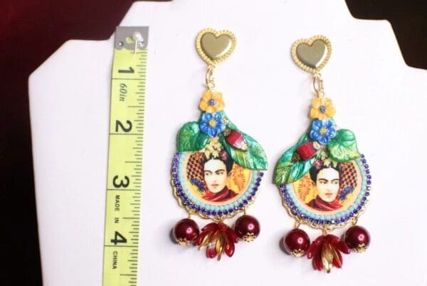 A pair of earrings with a heart and flowers.