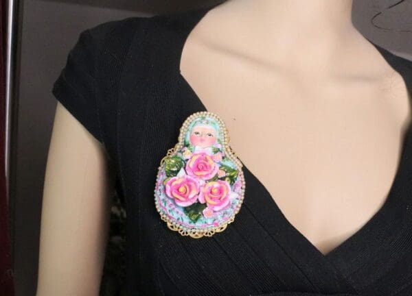A woman wearing a black shirt and a pink brooch