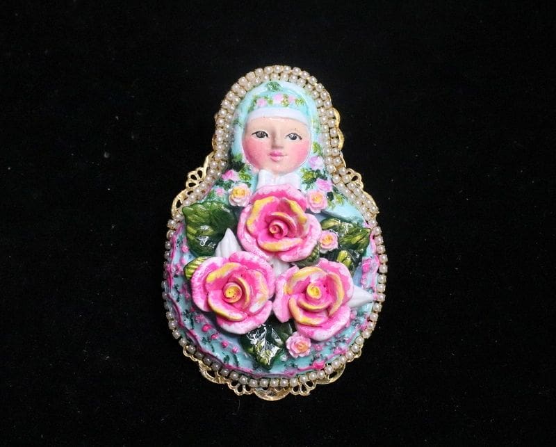 A doll with pink roses on it's head.