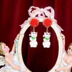 A pair of earrings hanging from the side of a picture frame.