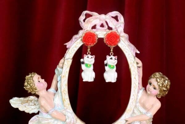 A pair of earrings hanging from the side of a picture frame.