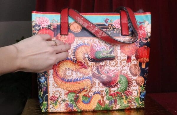 A person is holding onto the strap of a bag