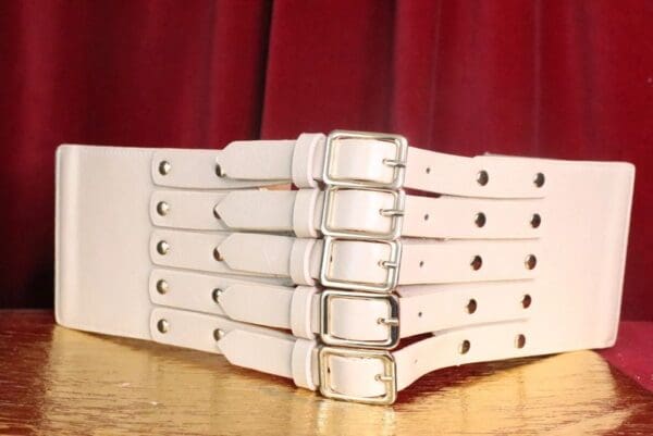 A close up of four white belts on top of each other