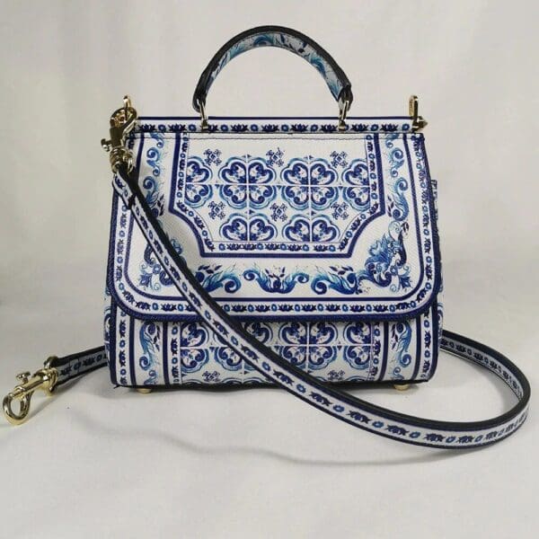 A blue and white purse with a strap around it.