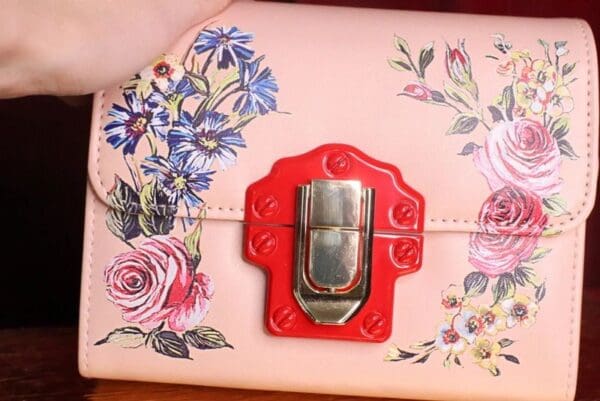 A close up of the red lock on a pink purse