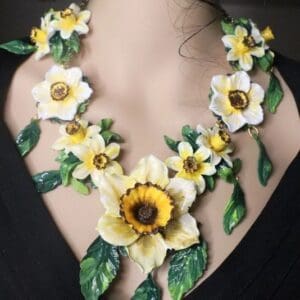 A woman wearing a necklace with flowers and leaves.