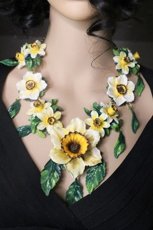 A woman wearing a necklace with flowers and leaves.