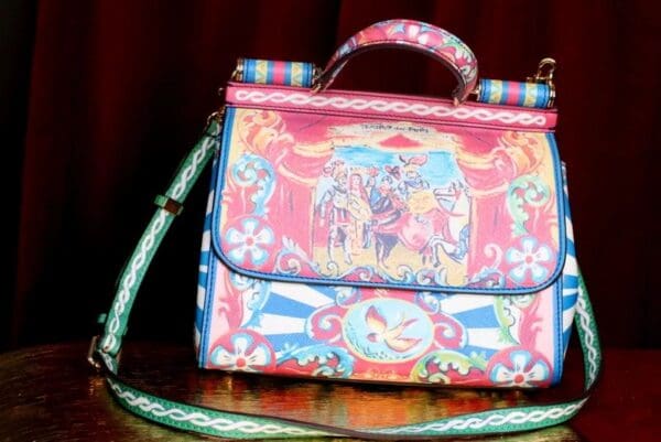 A colorful purse sitting on top of a wooden table.