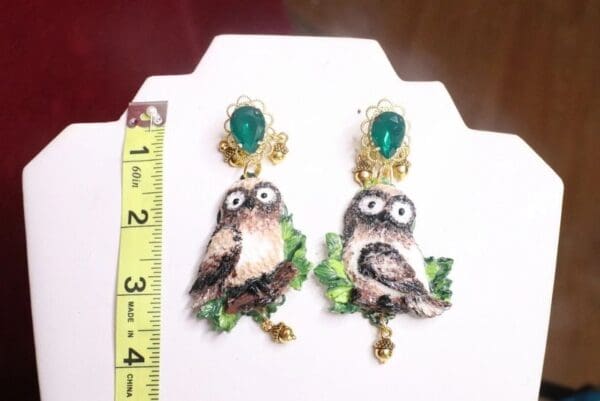 A pair of earrings with an owl on them