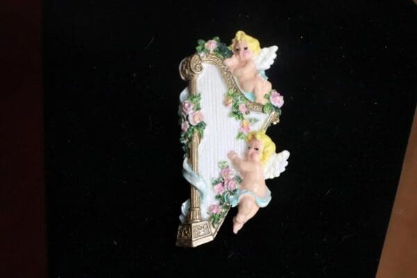 A picture of some little angels sitting on top of a mirror.