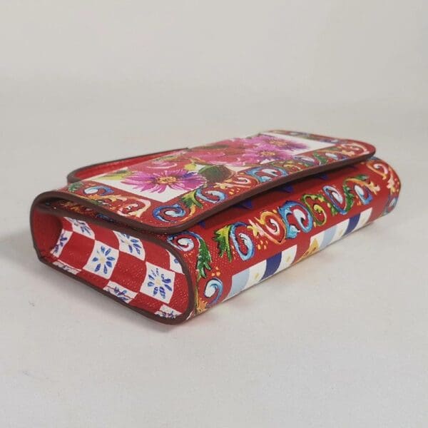 A red wallet with many different designs on it.