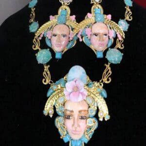 A necklace and earrings set with faces of women.