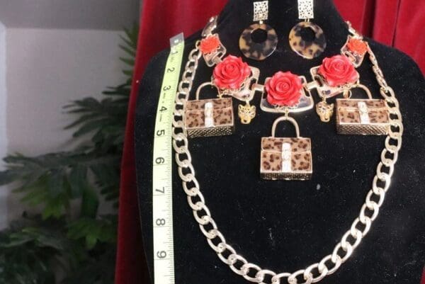 A necklace and earrings set with red roses.