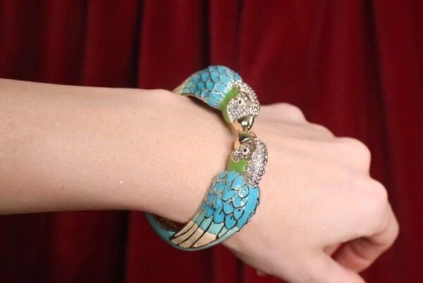 A woman 's hand wearing a turquoise bracelet.