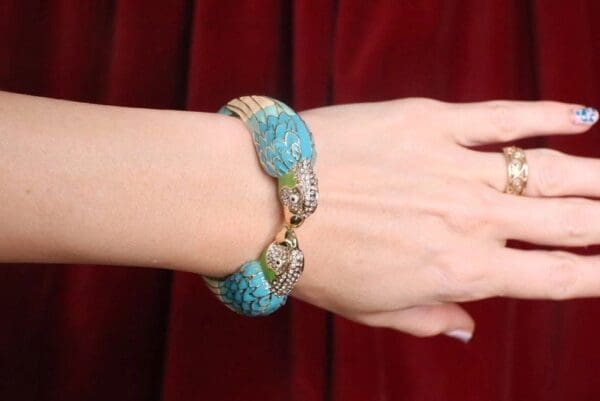 A woman wearing a bracelet with blue and green beads.