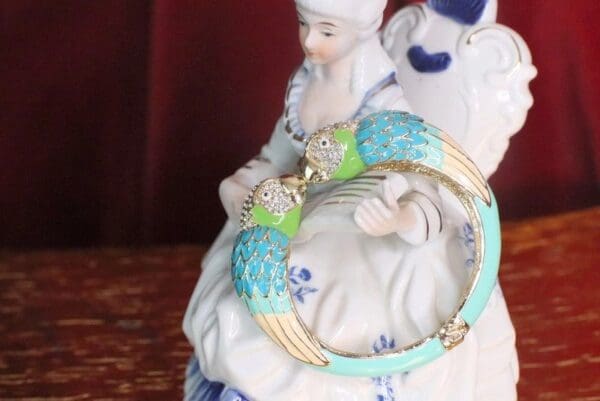 A figurine of two birds sitting on top of a statue.