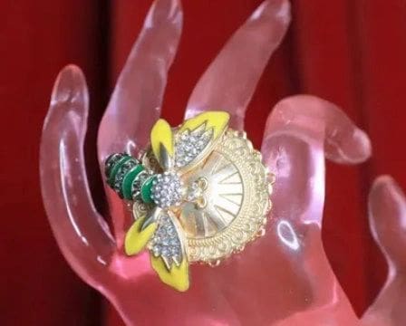 A close up of a hand with a bee pin