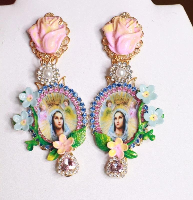 A pair of earrings with flowers and a picture.