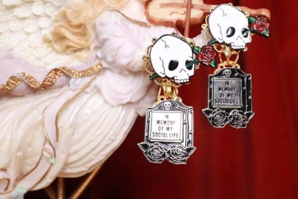 Two skulls are hanging from a white flower.