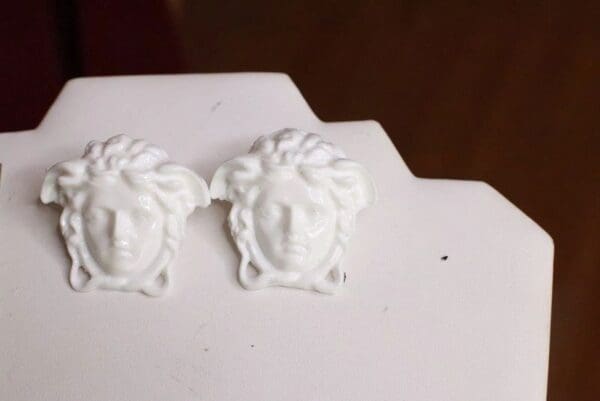 A pair of white earrings sitting on top of a table.