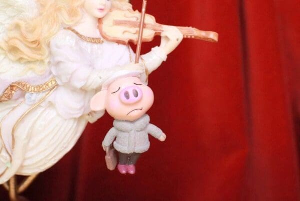 A stuffed pig hanging from the side of a string.