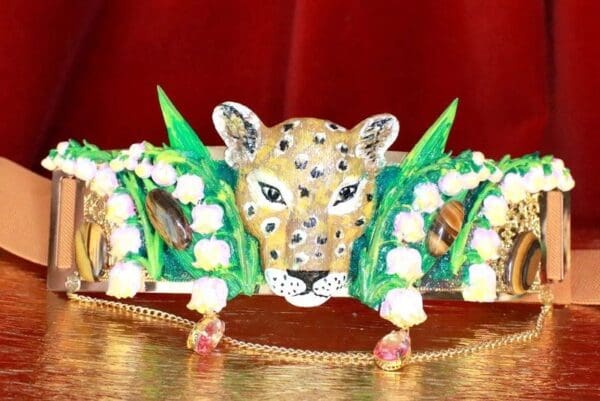 A leopard head with flowers and leaves on it.