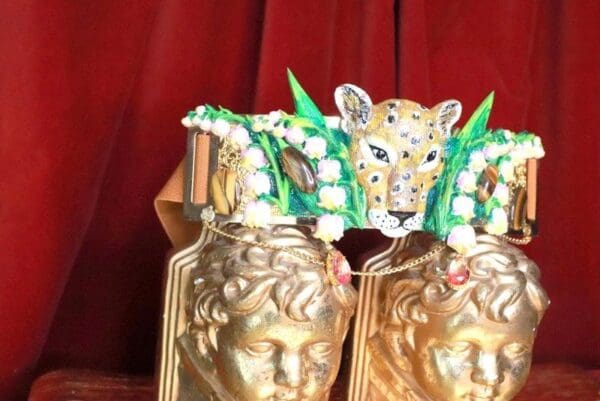 A pair of gold vases with faces on top.