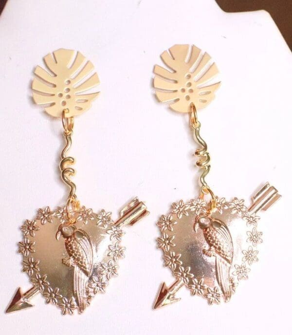 A pair of earrings with a heart and arrow.