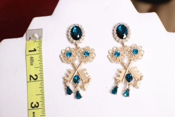 A pair of earrings with blue stones and gold tone.