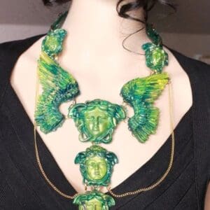 A woman wearing a necklace with green and yellow designs.