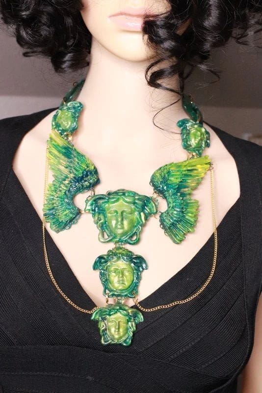 A woman wearing a necklace with green and yellow designs.