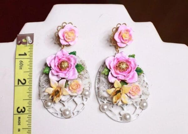 A pair of earrings with flowers on them.