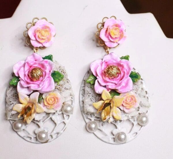 A pair of earrings with flowers on them.