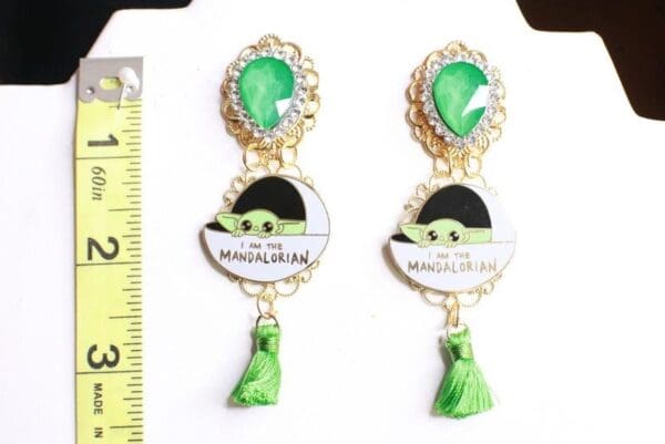 A pair of earrings with green stones and a frog.