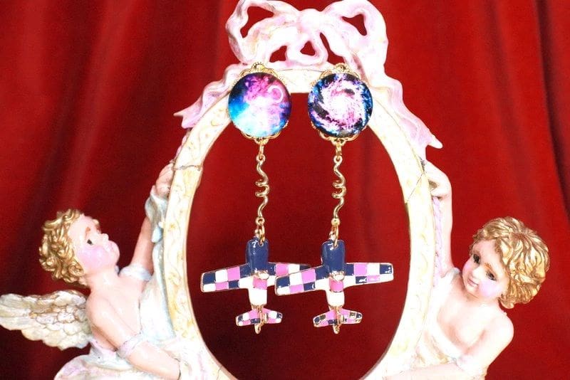 A pair of earrings hanging from the side of a mirror.