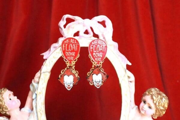 A pair of earrings with hearts and words on them.