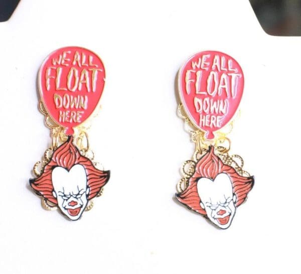 A pair of earrings with the words " we all float down here ".
