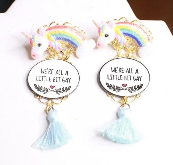 A pair of earrings with a rainbow and unicorn.