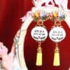 A pair of earrings with yellow tassels hanging from the bottom.