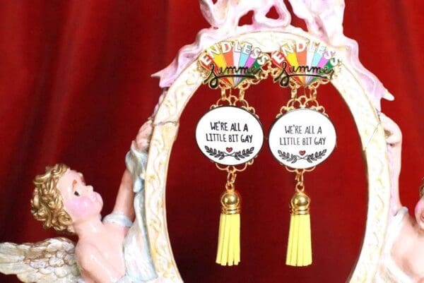 A pair of earrings with yellow tassels hanging from the bottom.