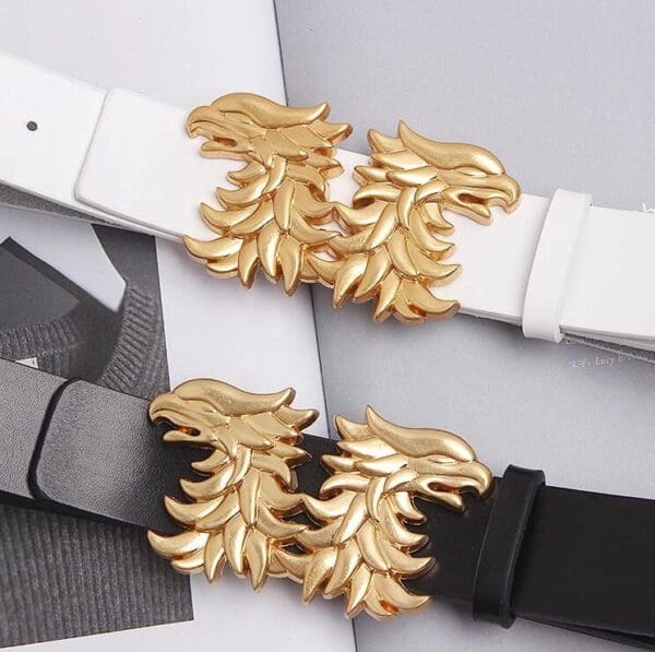 A pair of white and black belts with gold accents.