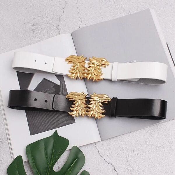 A pair of black and white belts with gold embellishments.
