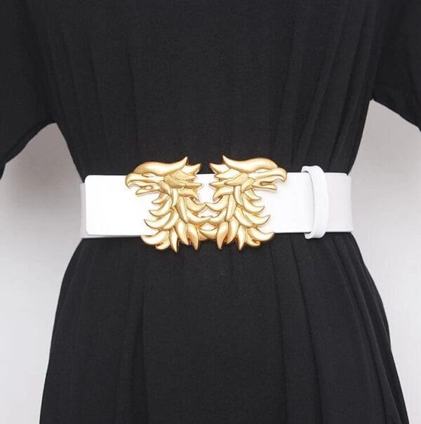A white belt with gold metal embellishments on it.