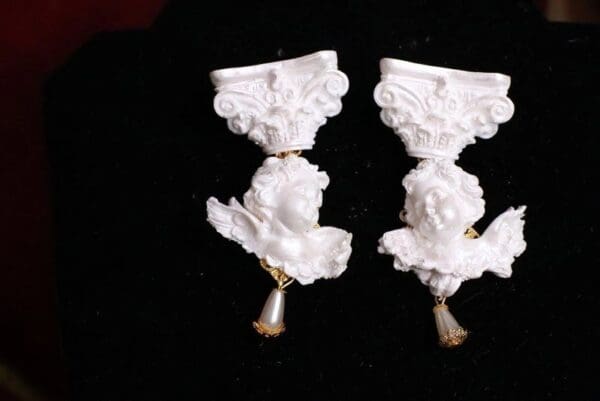 A pair of white statues with gold trim.
