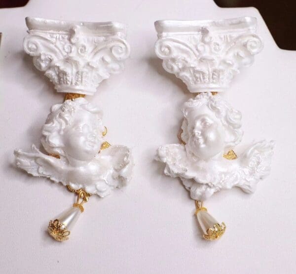 Two white handles with gold accents on a table.