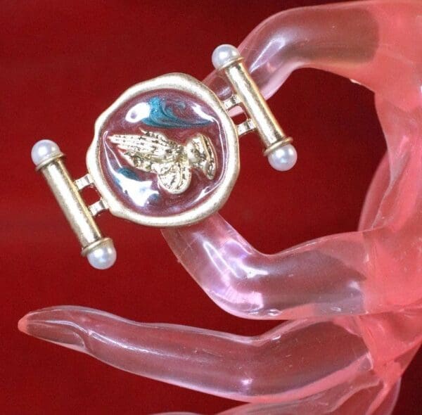 A hand holding something with a ring on it
