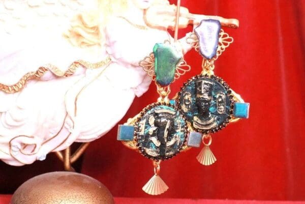 A pair of earrings with gold and blue stones.