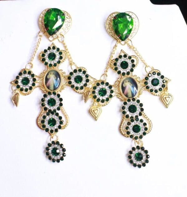 A pair of earrings with green stones and black beads.